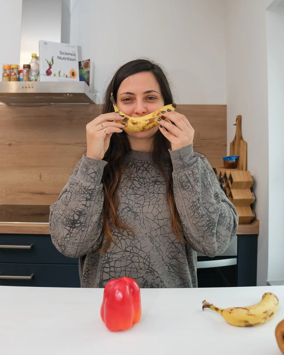 Aleks hält sich in ihrer Küche eine Banane als Lächeln vors Gesicht